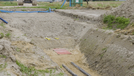 Detailansicht rückverfüllter Kabelgraben: Das NordLink-Kabel liegt in einem Sandbett, um es vor mechanischen Schäden zu schätzen. Darüber Schutzplatten, Unterboden, Trassenwarnband und Mutterboden.