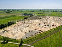 Im Vordergrund das Umspannwerk Wilster/West während des Ersatzneubaus im Juni 2019. Über dieses Umspannwerk wird NordLink (und später auch SuedLink) an das TenneT-Stromnetz angeschlossen. Im Hintergrund die NordLink-Konverterbaustelle.