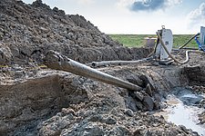 HDD-Bohrung am Binnendeich zur Unterquerung des Warwerorter Kanals bei Büsum, Schleswig-Holstein. Detailansicht des Bohrkopfes nach dem Austritt auf der anderen Seite des Deiches.