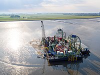 Seekabeleinzug von NordLink unter dem Büsumer Landesschutzdeich. Blick auf das Wattkabelverlegeschiff vor dem Büsumer Deich. Dort wird das NordLink-Seekabel in die Leerrohre eingeführt, die unter dem Deich zur Landseite hin verlaufen.